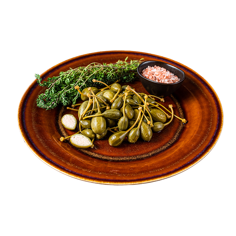 pickled_capers_berries_rustic_plate_isolated_white_background Capers a condiment commonly used in Mediterranean cuisine for its tangy and salty flavor, made from pickled flower buds of the caper bush.