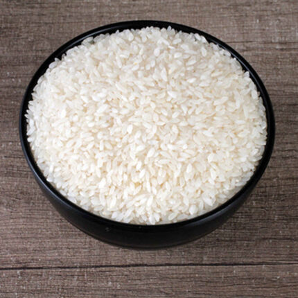The image may show a bowl of cooked Ambemohar rice or a pile of uncooked rice grains. Ambemohar rice is known for its distinctive aroma, reminiscent of mango blossoms (Ambemohar translates to "fragrance of mango blossoms").