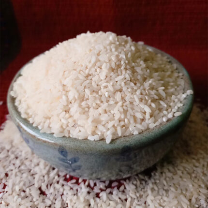 The grains of Dubraj rice are slender and long, with a pale golden color. The image may show a bowl of cooked Dubraj rice or a pile of uncooked rice grains.