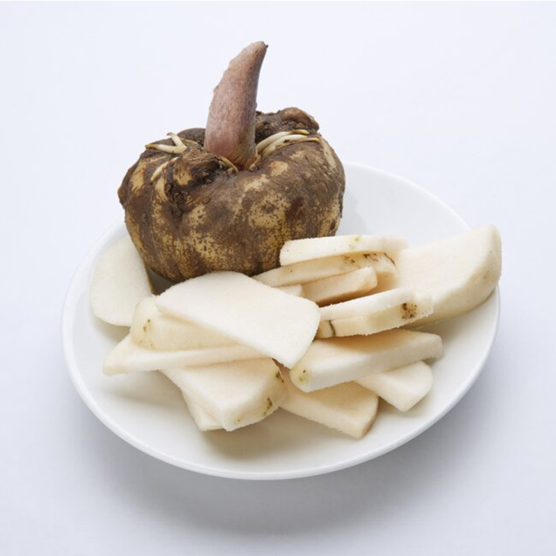 Konjac "An image of konjac, a plant commonly known for its starchy corms. Konjac corms are round and bulbous, with a brown outer layer. The image may also show konjac noodles or konjac powder, which are popular konjac-derived products. Konjac is used as a food ingredient and has gained popularity as a low-calorie, low-carbohydrate alternative to traditional pasta and rice. It is known for its gelatinous texture and ability to absorb flavors well.